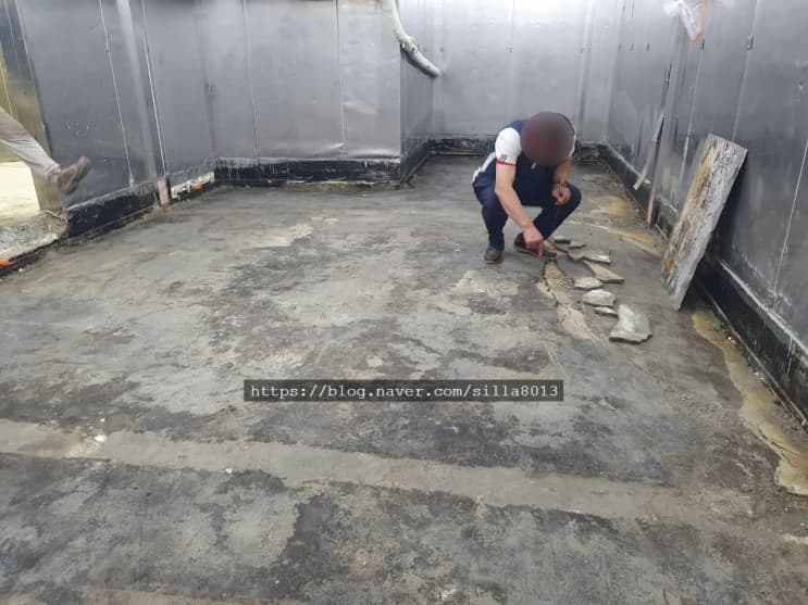 바닥 철거와 정리가 끝난 냉동창고 내부를 작업자가 확인하는 모습