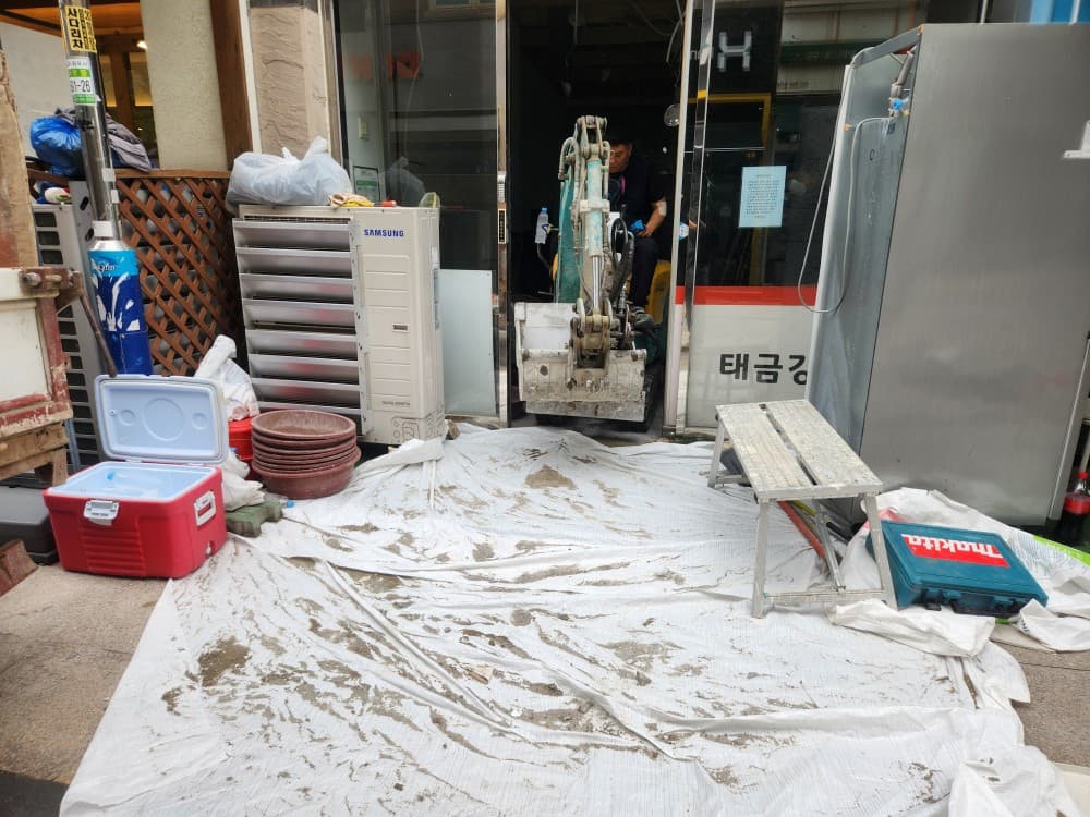 바닥에 보양재를 깔고 집기를 한쪽으로 정리한 철거 준비 모습