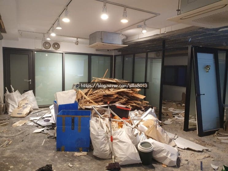 천장 마감재를 철거하는 작업자들과 잔해가 쌓인 모습